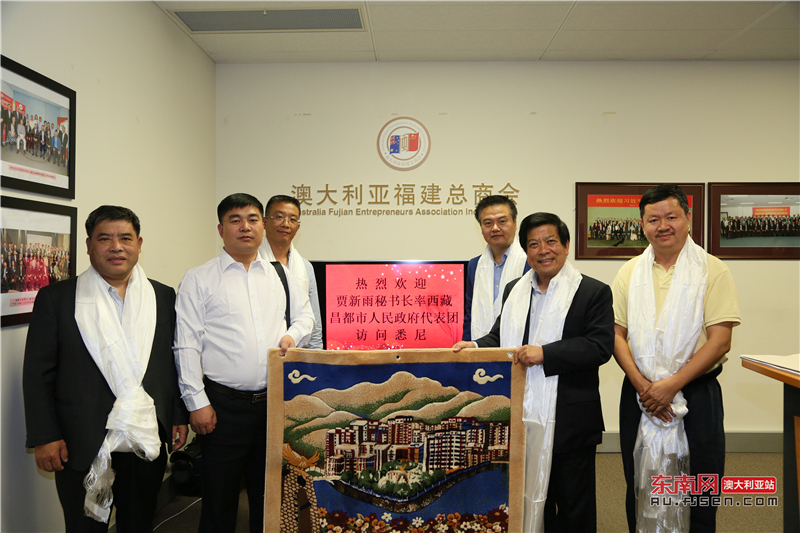 西藏昌都市人民政府秘书长贾新雨(左二)向总商会执行会长饶国辉(右二)